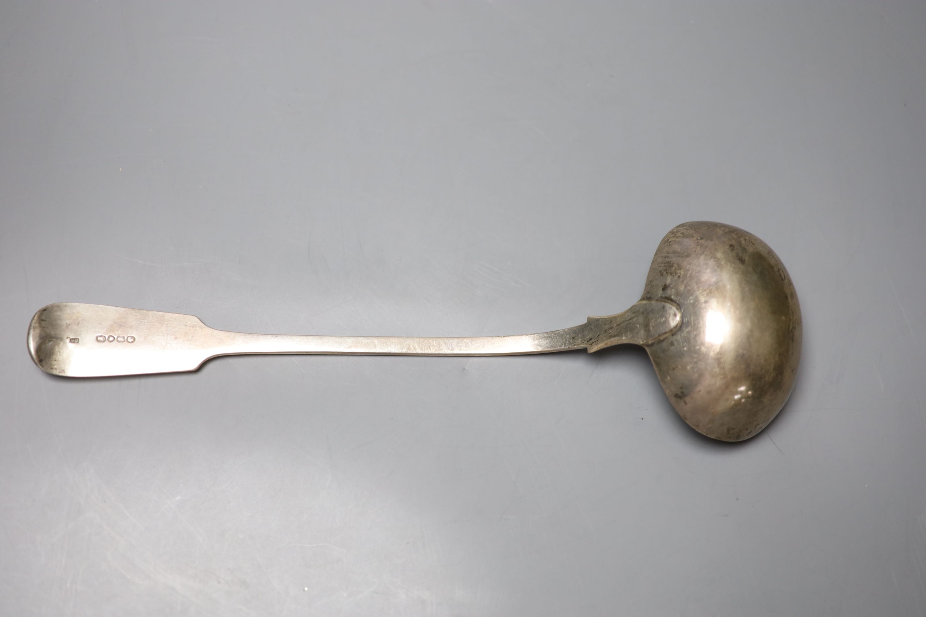 A Victorian silver fiddle pattern soup ladle, with engraved crest, William Smily, London 1862, 34.2cm, 9oz.